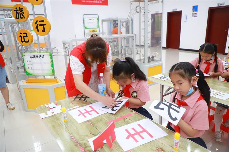 2021年7月10日，鄂州市科協(xié)組織落駕坪小學(xué)學(xué)生在鄂州市科技館開展社會(huì)主義核心價(jià)值觀系列活動(dòng)，圖為開展的紅色剪影圓夢(mèng)中華剪紙活動(dòng)，志愿者指導(dǎo)同學(xué)們.jpg