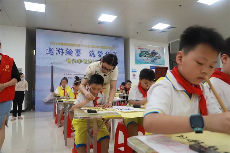 2021年7月10日，鄂州市科協(xié)組織蓮花小學(xué)學(xué)生在鄂州市科技館開展社會(huì)主義核心價(jià)值觀系列活動(dòng)，圖為開展的遨游翰墨筑夢(mèng)華夏書法活動(dòng)，老師指導(dǎo)學(xué)生.jpg